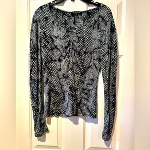 Woman’s medium long sleeve Dunia blouse. Black and green/gray patterned.